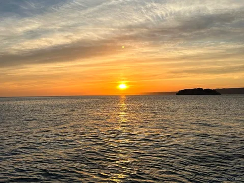 Gäste entspannen an Deck während der Sonnenuntergang Katamaran Kreuzfahrt in Marseille